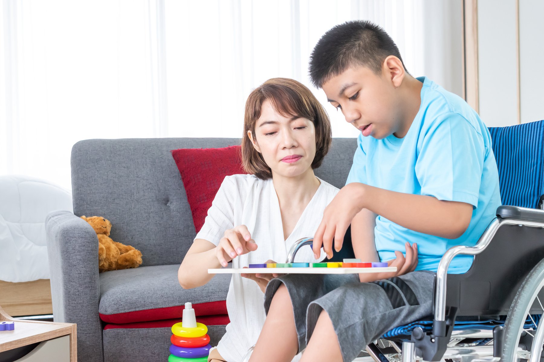 woman playing with disabled child on wheelchair